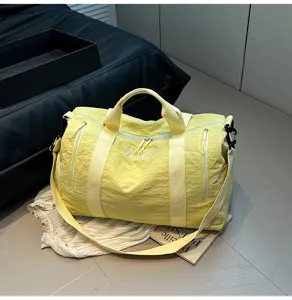 Vue détaillée du sac de voyage jaune montrant la texture, les fermetures et les lanières.