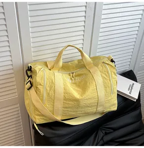 Détail de sac de voyage jaune avec tissu résistant, fermetures éclair robustes et grand espace.