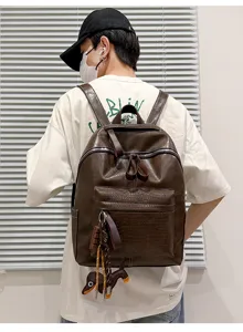 Backpack detail view showing retro brown PU leather, crocodile texture pocket, and smooth metal zippers.