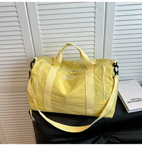 Vue détaillée du grand sac de voyage jaune, montrant son tissu durable et ses fermetures éclair.