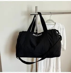 Gros plan détaillé du sac de voyage noir montrant un tissu robuste et une sangle.