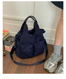 Detail view of casual nylon tote shoulder bag with multiple pockets and cross-body strap.