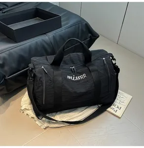 Vue détaillée du sac de voyage noir montrant le tissu durable et l'impression frontale.