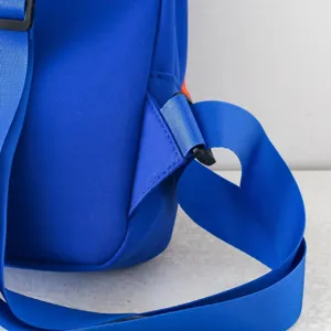 Close-up detail of the blue kids chest bag strap and durable plastic buckle, fine stitching.