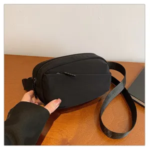 Black nylon waist bag detail view, casual chest crossbody bag with zipper pocket.