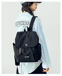 Detailed view of the lightweight Japanese style black backpack worn by model, pockets.