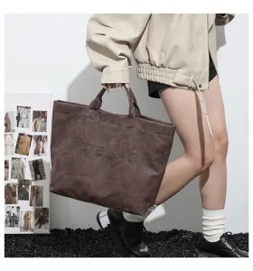Detailed view of large capacity tote bag with studded lettering design, perfect for daily commute.