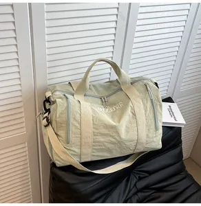 Détail de sac de voyage vert, sac de sport fitness léger avec sangle et poches avant.