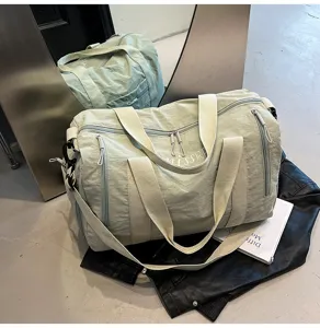 Détail de sac de voyage vert clair avec poches multiples et bandoulière robuste pour sport.