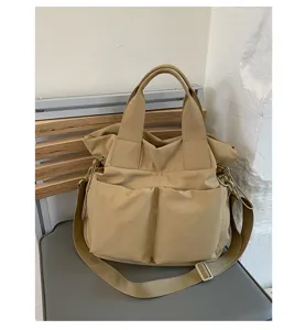 Detailed view of casual nylon canvas shoulder tote bag with multiple front pockets and strap.