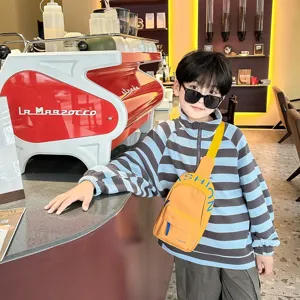 Details of trendy kids chest bag in bright yellow with blue stripes, fashion street style.