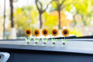 Cute sunflower shaking car dashboard ornament, fresh floral interior decoration detail shot.