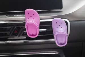 Close-up detail van mini clog schoen auto luchtventiel parfum clip, schattig miniatuur ontwerp.
