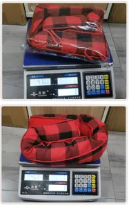 Detail shot of red black buffalo plaid Christmas door draft stopper displayed on weighing scale.