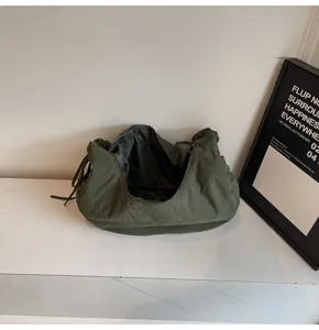 Detailed view of dark green nylon dumpling bag, casual commuter shoulder cloud bag