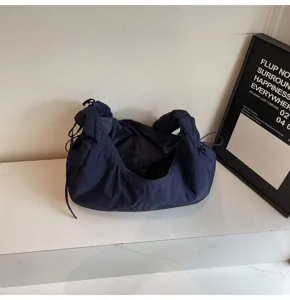 Detailed view of dark blue nylon dumpling bag featuring trendy pleated cloud design.