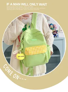 Detail view of the cute green mini backpack with yellow plaid pocket and sweet accessories.
