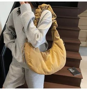 Detailed view of the casual nylon pleated hobo shoulder bag shown in indoor staircase scene.