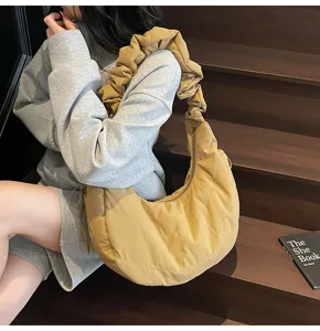 Detailed view of the stylish nylon dumpling bag with ruffled strap, shown on stairs.