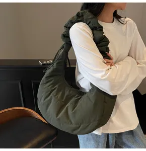 Detail view of the dark green nylon cloud dumpling shoulder bag showing strap and fabric.