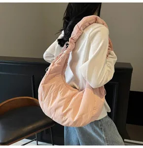 Detailed shot of a pink puffy dumpling bag, stylish cloud shoulder crossbody bag for women.