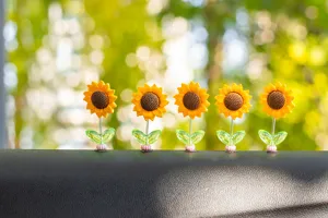 Closeup detail of cute shaking sunflower car dashboard ornaments set of five spring flower decor.