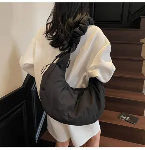 Black nylon dumpling shoulder bag for women, casual commuter crossbody cloud bag with ruffles.