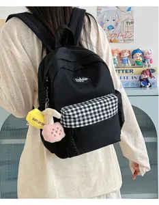 Casual black canvas backpack for women with plaid front pocket and charms stylish bag.