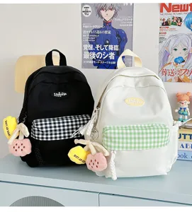 Cute mini canvas backpack for women, versatile school bag with plaid pocket and plush charm.