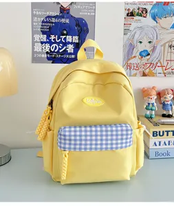 Casual yellow canvas backpack with blue plaid front pocket for daily school and travel use.