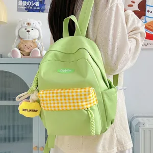 Casual mini backpack for women, cute green school bag with plaid pocket and charms.
