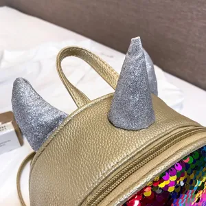 Close-up detail shot of kids metallic gold mini backpack with glitter horns and sequins.