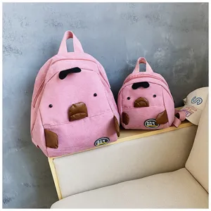 Detail view of cute pink corduroy mini backpack with funny cartoon animal design for students.