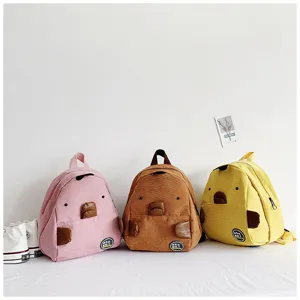 Detailed view of cute corduroy mini backpacks in pink, brown, and yellow with animal designs.