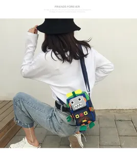Dettaglio della borsa a tracolla in tela robot carina, design giocoso con blocchi di colore.