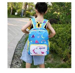 Outdoor detail shot of a cute blue kids school bag with unicorn prints worn by child.