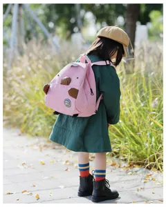 Detailed outdoor scene showing the cute pink corduroy mini backpack with lovely animal details.
