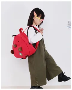 Cute kids red corduroy dinosaur backpack, playful mini cartoon school bag for toddler girls.
