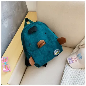 Close-up detail of the cute teal corduroy animal backpack, showing soft fabric and cute design.