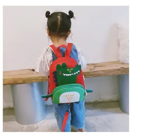 Detail view of cute dinosaur toddler backpack with leash, showing cute green dinosaur shape.