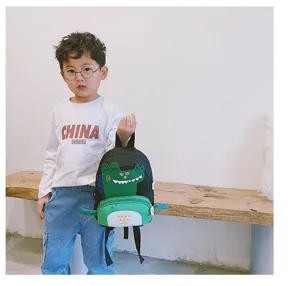 Cute dinosaur cartoon children backpack for kindergarten boys, stylish and fun black green bag.