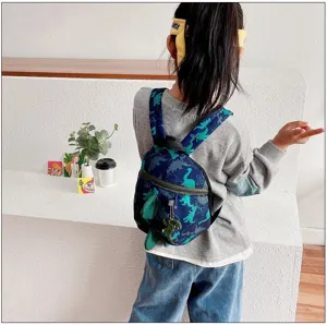 Cute dinosaur print toddler backpack detail view, featuring 3D wings and front zip pocket.
