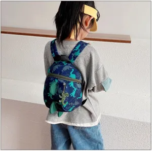 Kids cartoon dinosaur backpack detail view, cute toddler school bag with soft straps and pendant.