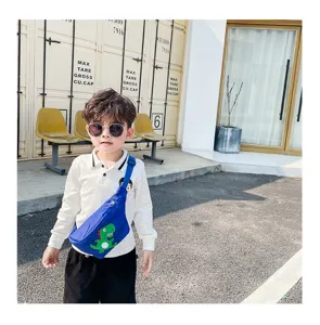 Cute children sling bag detail showcasing adorable cartoon dinosaur print and blue nylon fabric.