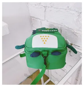 Detail close-up of cute green dinosaur toddler anti-lost backpack on clean white glass table surface