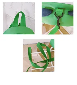 Detail view of the green kids dinosaur backpack strap, handle, and anti-lost leash buckle.