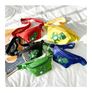 Detailed view of colorful kids waist bags with cute dinosaur patches on white fabric background.