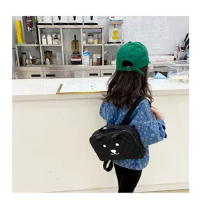 Zwarte gewatteerde kinderrugzak en handtas met schattig berenontwerp en zachte orenstijl.