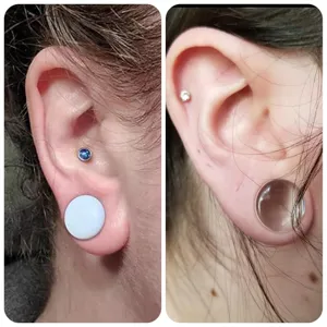 Detail view of ear stretching plugs and tunnels with O-rings, body piercing jewelry close up.