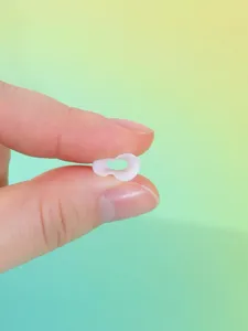 Close-up detail of flexible transparent silicone ear piercing stretcher and expanding tunnel jewelry.